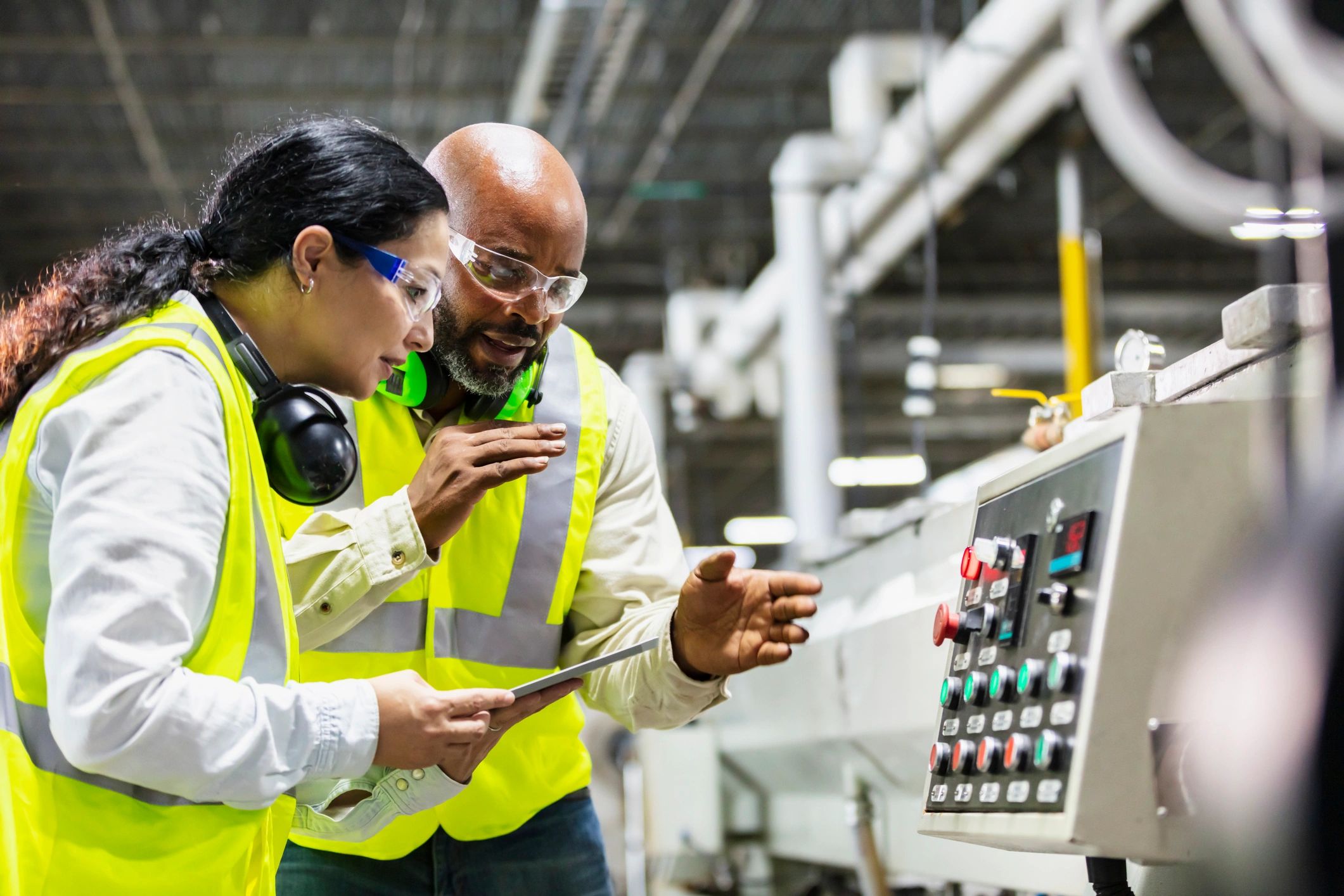 Factory team reviewing machine controls during production